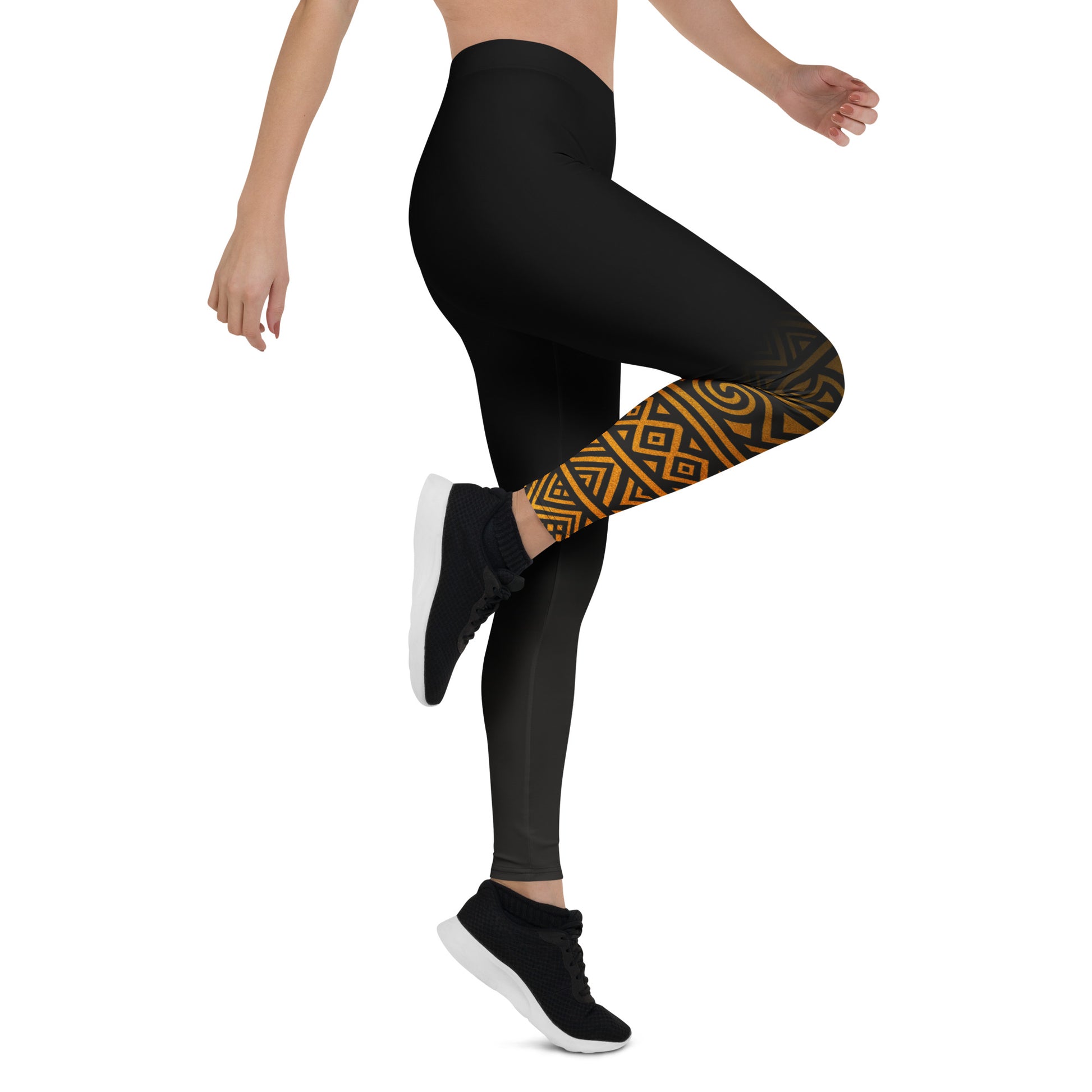 Black leggings with a gold geometric pattern on one leg, worn by a person on a white background