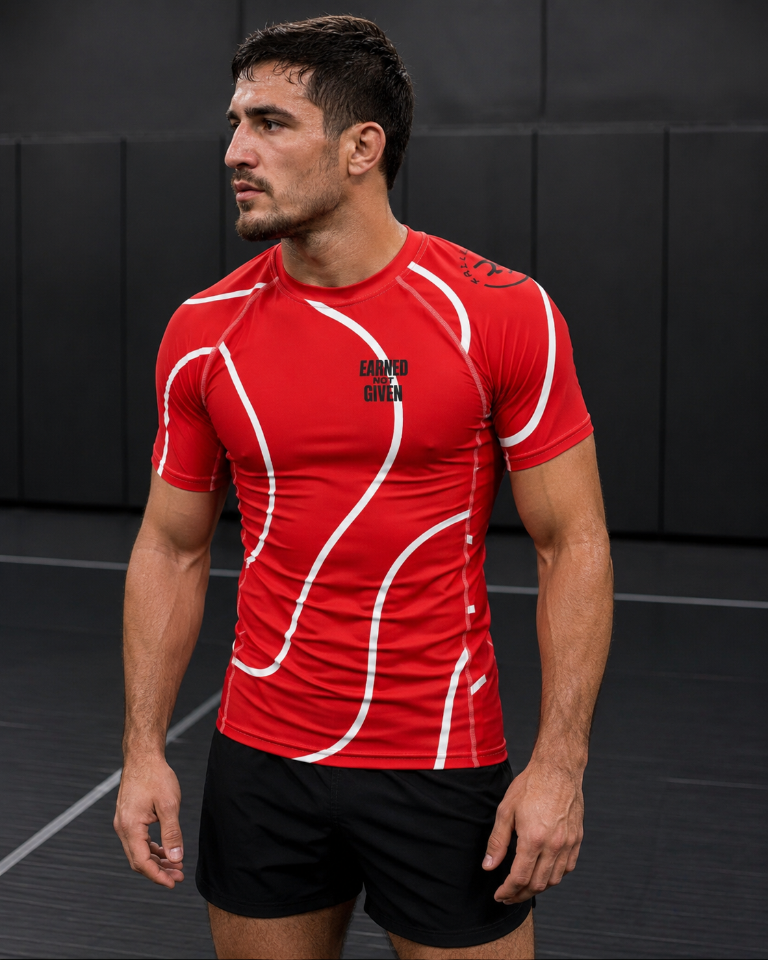 Man wearing a red athletic shirt with white designs and black shorts on a dark background