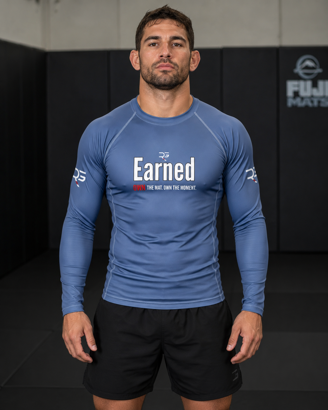 Man wearing a blue athletic shirt with 'Earned' text in a gym setting