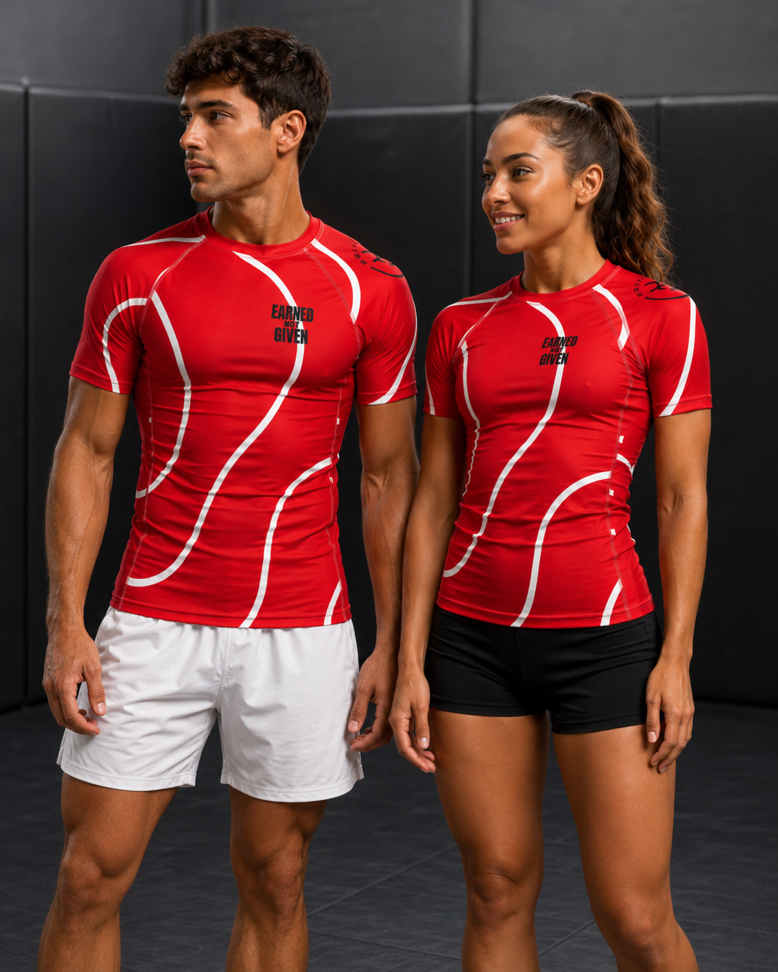 Two people wearing red athletic shirts with white patterns on a dark background