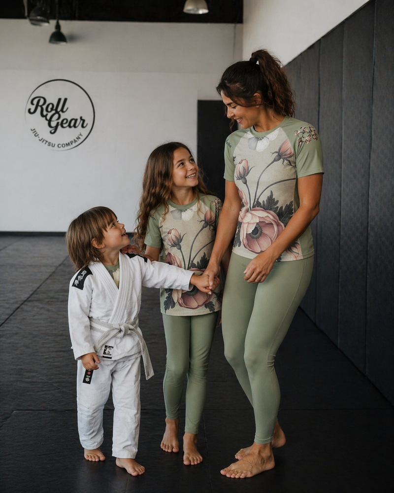 Woman and two children in athletic wear standing together in a gym setting.