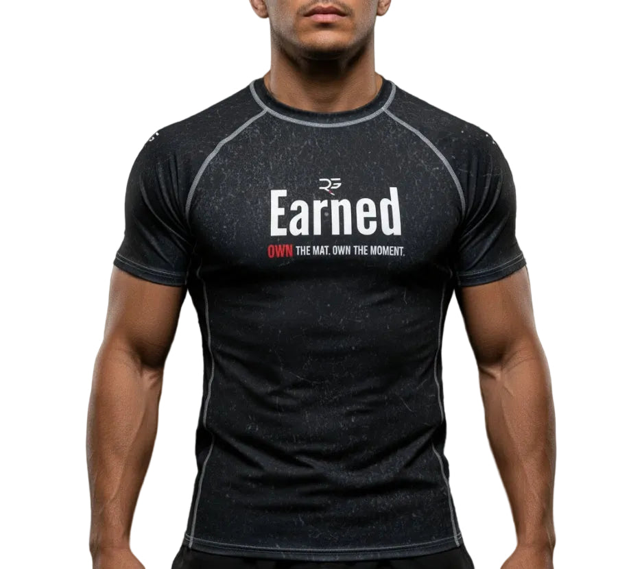 Man wearing a black athletic shirt with 'Earned' logo against a dark background
