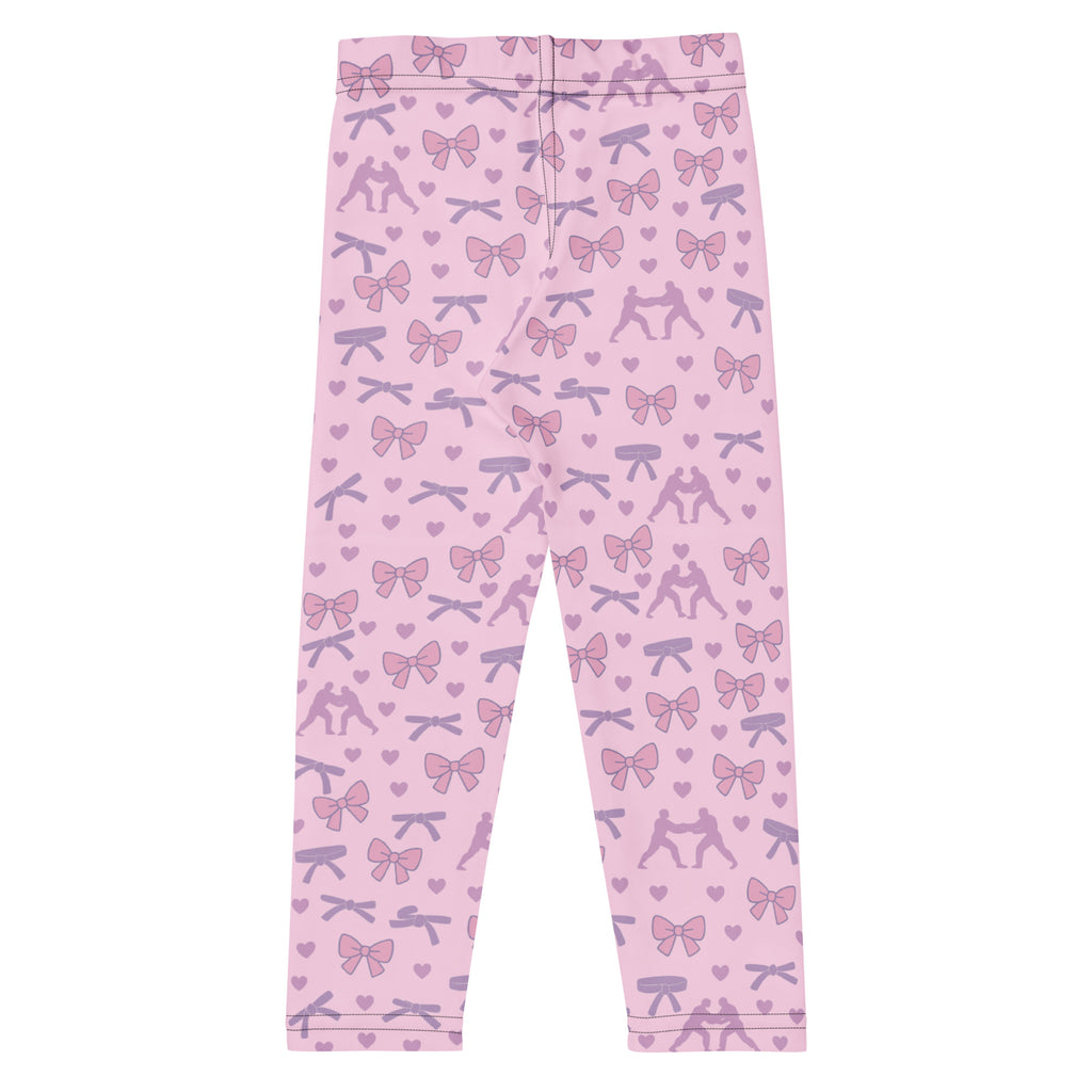 Kids BJJ spats in pink, black, and white with no text, designed to match the Bows, Belts & Armbars rash guard. Roll gear llc