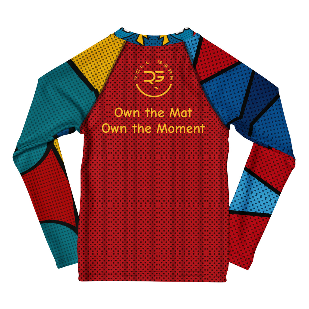 Kids long-sleeve rash guard with vibrant comic pop art design featuring bold red, blue, yellow, and teal color blocks, comic-style graphics, and text bubbles saying POP! and WOW MOM. Unisex limited edition training gear for boys and girls in BJJ, wrestling, and MMA.” Roll gear 