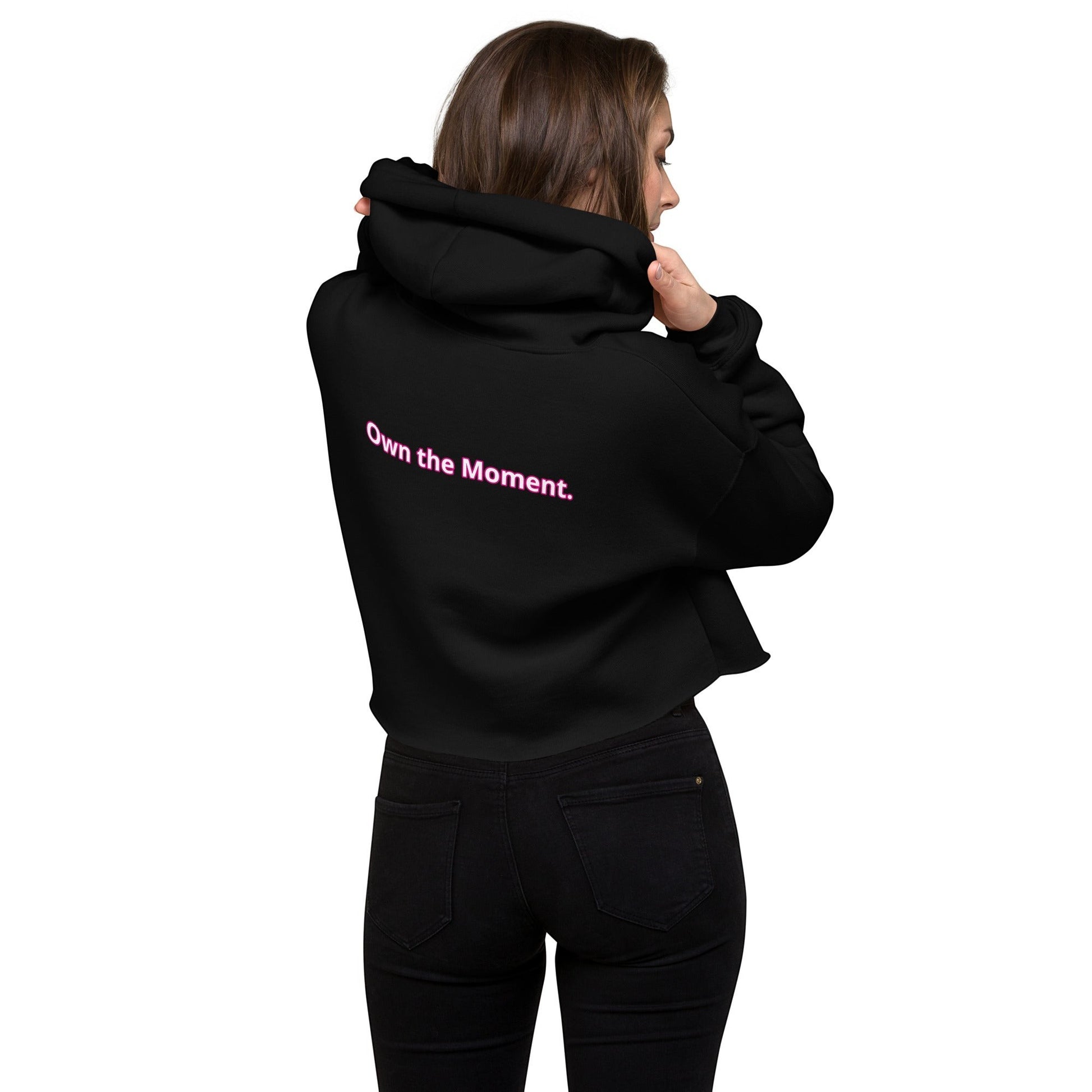 Roll Gear black cropped hoodie with pink "Own the Moment." text on back. Women's BJJ lifestyle apparel.