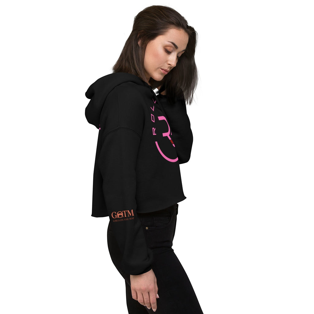 Roll Gear women's black cropped hoodie with pink logo on chest and sleeve. Model wears black jeans.