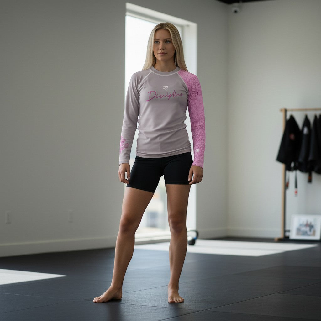 Roll Gear grey long sleeve youth performance rash guard with pink patterned sleeves and 'Discipline' text.