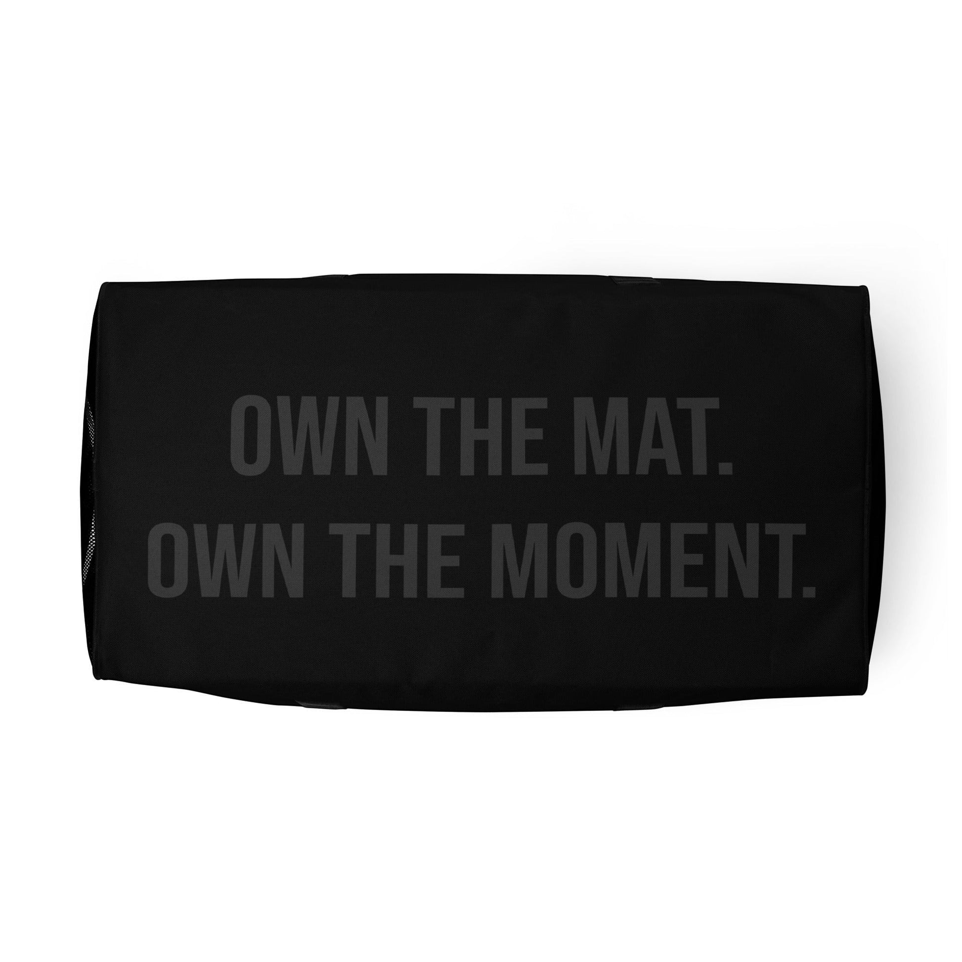 Roll Gear LLC black polyester duffel bag with "OWN THE MAT. OWN THE MOMENT." text.
