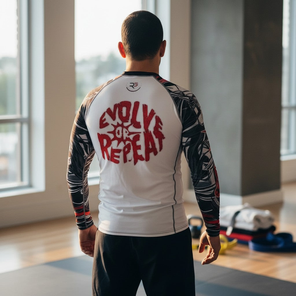 Roll Gear men's white long sleeve rash guard with red and black graphic print and "Evolve or Repeat" text.