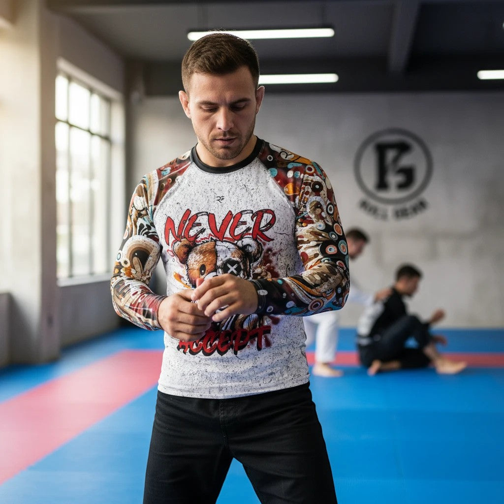 Roll Gear men's long sleeve rash guard with "Never Accept" graphic and colorful, abstract sleeve art. Moisture-wicking fabric.