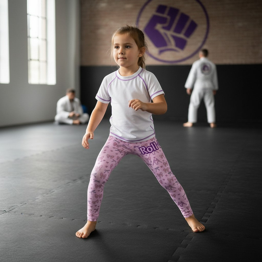 Roll Gear girls pink microfiber spats with all-over bow pattern, elastic waistband, for gymnastics and play.