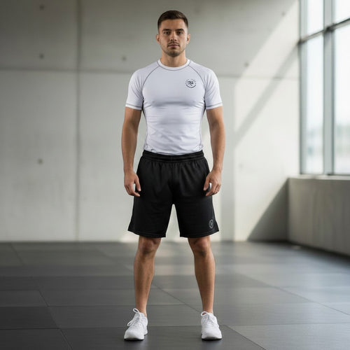 Roll Gear white short-sleeve rash guard with grey stitching and logo, worn by a man in black shorts for athletic training.