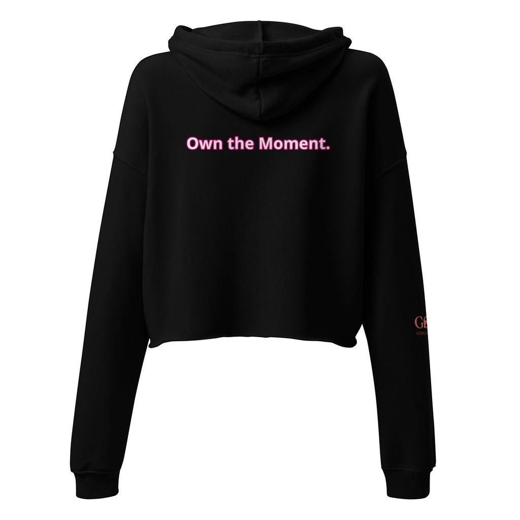 Roll Gear Women's black cropped hoodie with pink text 'Own the Moment.' on back. Ribbed cuffs and hem.