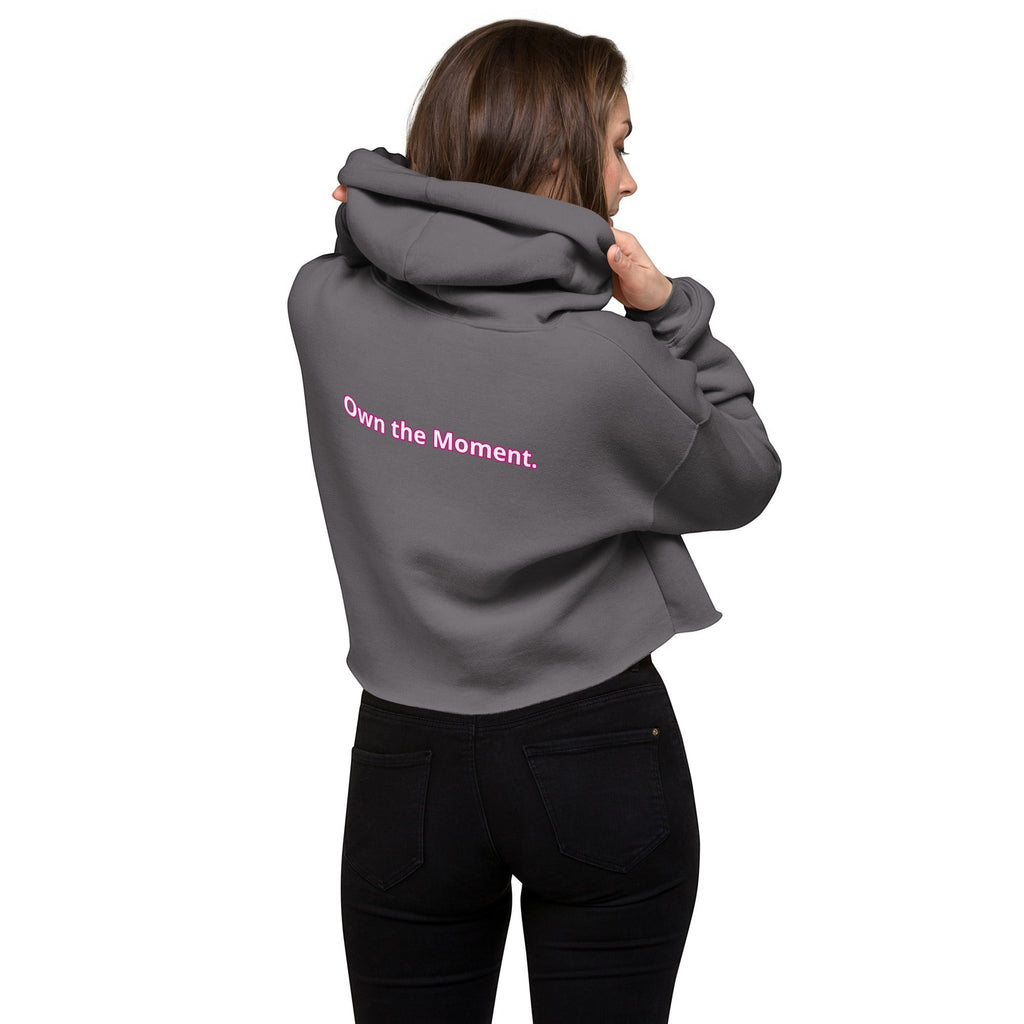 Roll Gear women's cropped grey hoodie with pink text "Own the Moment." on the back. Comfortable fleece interior.