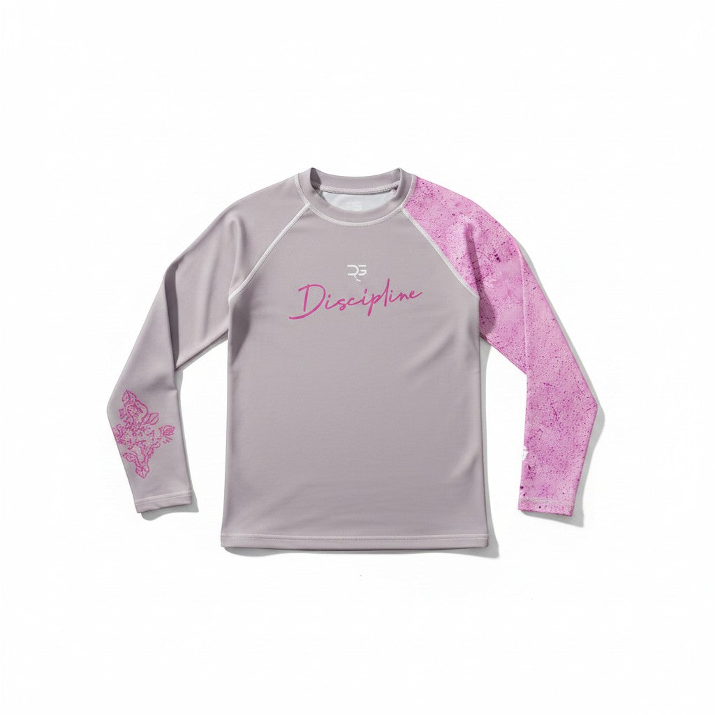 Roll Gear youth performance rash guard in grey with pink accents and long sleeves, featuring a 'Discipline' graphic.